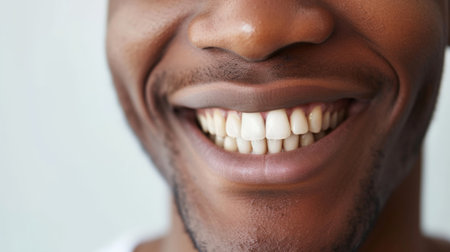 Cropped shot of a young African smiling man. Teeth whitening. Dentistry, dental treatment.の素材
