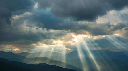 Rays of light shining through dark clouds It's gonna rain, dramatic sky with cloud, Sky background on sunrise nature composition The beam of light through the dark clouds on the mountains.の素材