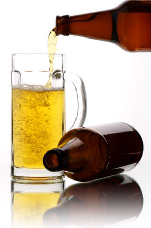 Beer flows from a bottle in a mugの写真素材