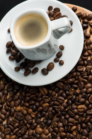 Cup of italian espresso with coffee beans all aroundの写真素材