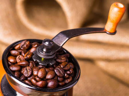 Roasted coffee beans and coffee grinder on golden wood table,still lifeの写真素材
