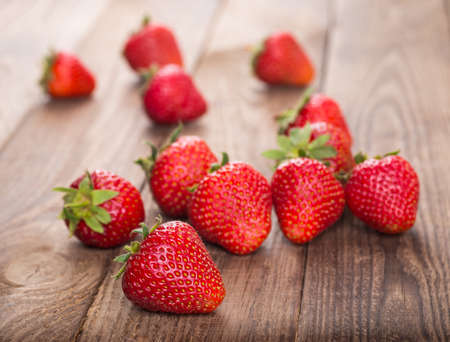 Ripe red strawberries on wooden tableの写真素材