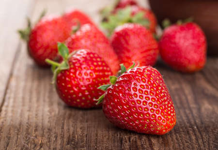 Ripe red strawberries on wooden tableの写真素材