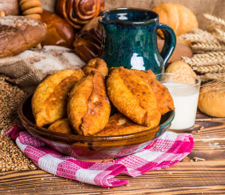 Traditional homemade pies with cabbage and sauerkraut on a plate. Freed Russian pastry pies on a wooden backgroundの写真素材