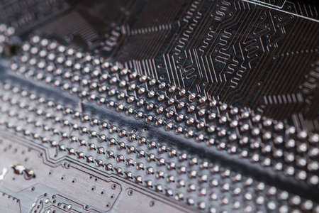 Macro closeup of a computer PCB  using brown and black colors with silver soldered terminalsの写真素材