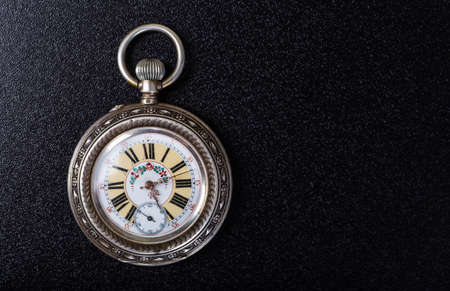 Old pocket watch on a black tableの写真素材
