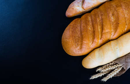 Assortment of baked bread on wooden table backgroundの写真素材
