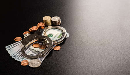 Handcuffs and money on the tableの写真素材