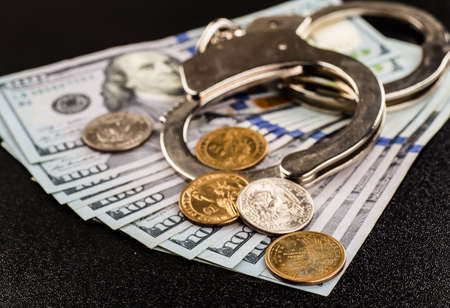 Handcuffs and money on the tableの写真素材