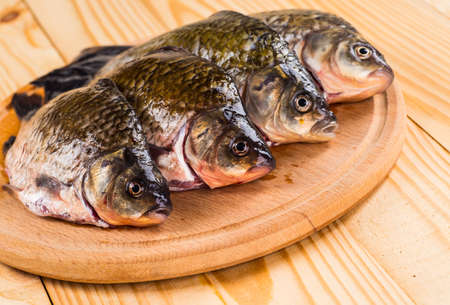 Fresh raw fish and food ingredients on tableの写真素材