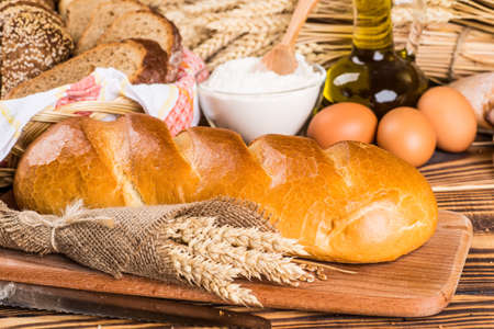 Assortment of baked bread on wooden table background