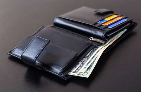 dollars bills in wallet isolated on blackの写真素材