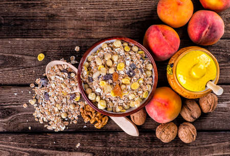 oatmeal in a sac, dried apricots, raisins, grapes, nuts on the background of wooden planks and sackingの写真素材