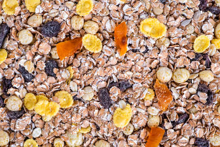 oatmeal in a sac, dried apricots, raisins, grapes, nuts on the background of wooden planks and...