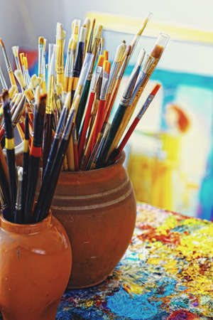 Paint brushes in the cup and palette paints