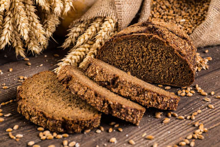 Assortment of baked bread on wooden table background