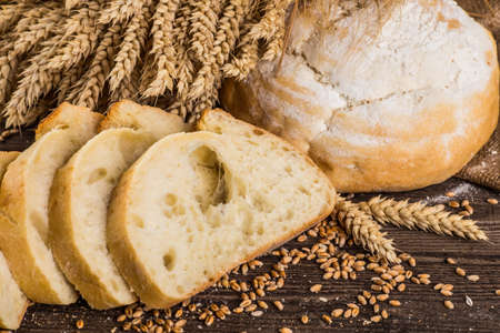 Assortment of baked bread on wooden table background