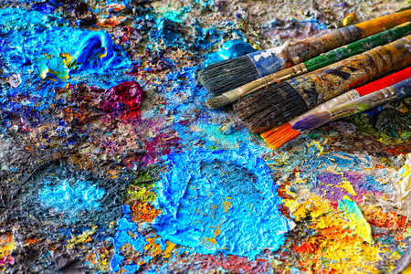 Paints and brushes,lying on painted backgroundの写真素材
