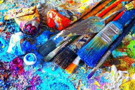 Paints and brushes,lying on painted backgroundの写真素材