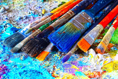 Paints and brushes,lying on painted backgroundの写真素材