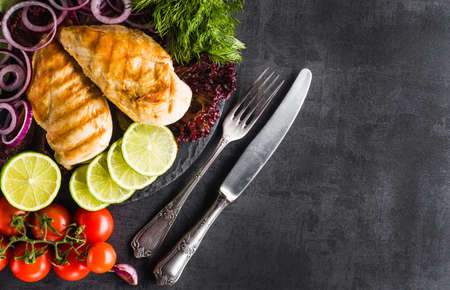 Grilled chicken fillets on slate plate. Gray concrete backgroundの写真素材