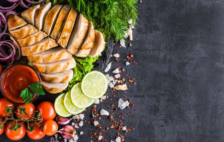 Grilled chicken fillets on slate plate. Gray concrete backgroundの写真素材
