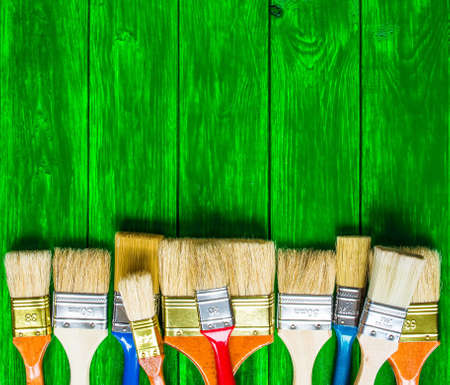 Painter and decorator work table with house project, color swatches, painting roller and paint brushesの写真素材