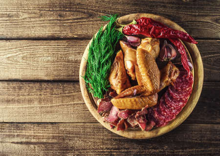 Food tray with delicious salami, pieces of sliced ham, sausage, tomatoes, salad and vegetable.の写真素材