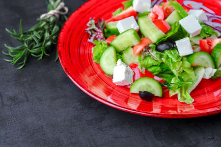 Greek salad feta, cherry tomatoes, olives, cucumbers on a dark background. Top view. Food backgroundの写真素材