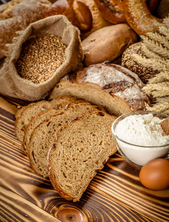 Assortment of baked bread on wooden table backgroundの写真素材