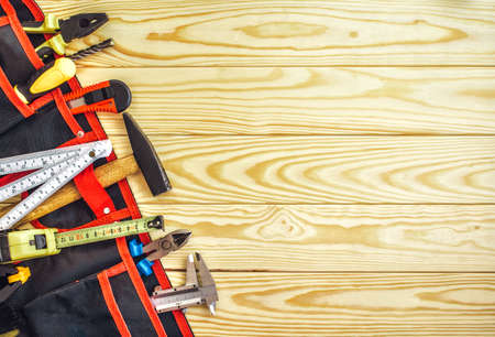 tools in tool belt on wood planks with copy spaceの写真素材