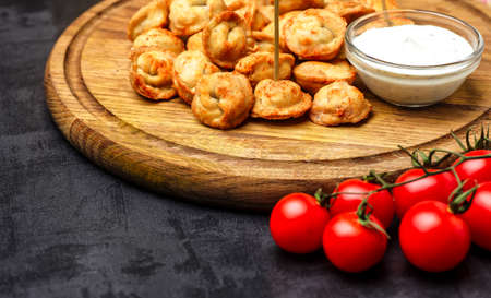Dumplings stuffed with meat sprinkled with fresh herbs , top view, black backgroundの写真素材