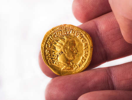 Gold Roman aureus coin of Roman emperor Trajan AD 98-117 isolated on a white backgroundの写真素材