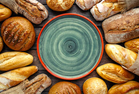 Assortment of baked bread on wooden table background,top viewの写真素材