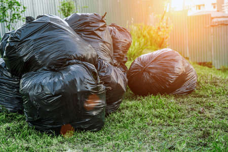 Heap garbage plastic bags many in the garden, pollution from trash bag waste. Pollution, trash.Nature ecology problem, threat of pollution, global warming, clean earth concept.の写真素材