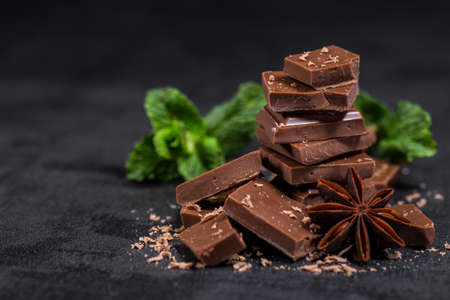 Hazelnut and almond milk and dark chocolate pieces tower.Chocolate bar pieces. Sweet food photo concept. The chunks of broken chocolateの写真素材