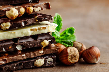 Hazelnut and almond milk and dark chocolate pieces tower.Chocolate bar pieces. Sweet food photo...