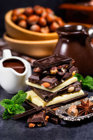 Hazelnut and almond milk and dark chocolate pieces tower.Chocolate bar pieces. Sweet food photo...