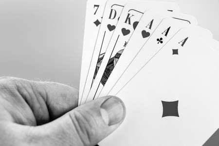 Playing cards in hand isolated on white backgroundの写真素材