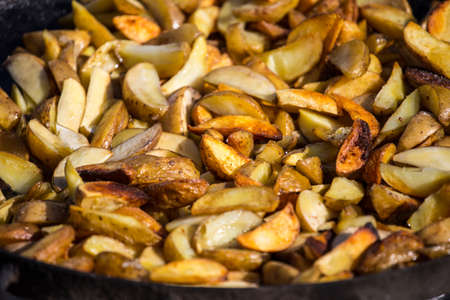 Roast potatoes in a large pan. Delicious food at the festival. Many potatoes on the table in a metal tray.の写真素材