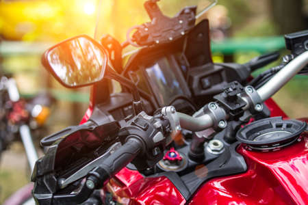 The chromed handlebar of a motorcycle.Travel and freedom, outdoor activities. View of motorcycle handlebar in the background many motorbikes blurred, concept of speed and travel in natureの写真素材