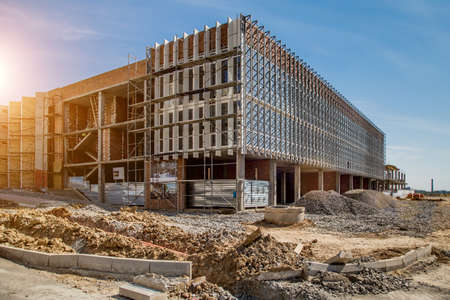 Construction site background. Hoisting cranes and new multi-storey buildings. I.ndustrial background.Building construction site work against blue skyの写真素材