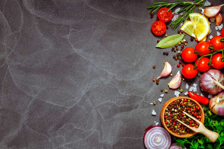 Fresh herbs and spices on black stone table. Cooking concept.Free space for your text. Rustic style....