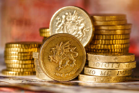 British Pound Coins against a background of British assorted bank notes,Business concept