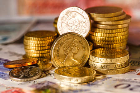 British Pound Coins against a background of British assorted bank notes,Business concept
