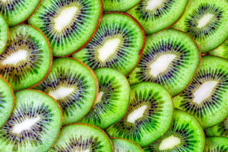 Top view of heap of sliced kiwi as textured background.Fresh and ripe slices of kiwi fruit, great summer wallpaper backgroundの写真素材