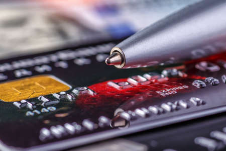 Credit card and ball pen,Online payment for purchases from online stores. Online shopping.Credit card close-up. Plastic card on black backgroundの写真素材