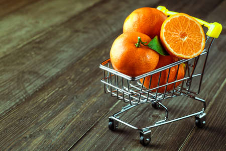 Ripe Mandarin fruit peeled open and place on old rustic look timber with group of mandarin fruits...