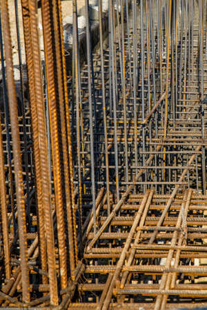 steel rebar for reinforcement concrete at construction site with house under construction...