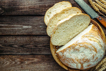 loaf of bread on wooden background, food closeup.Fresh homemade bread.French bread. Bread at leaven.Ciabatta.の写真素材